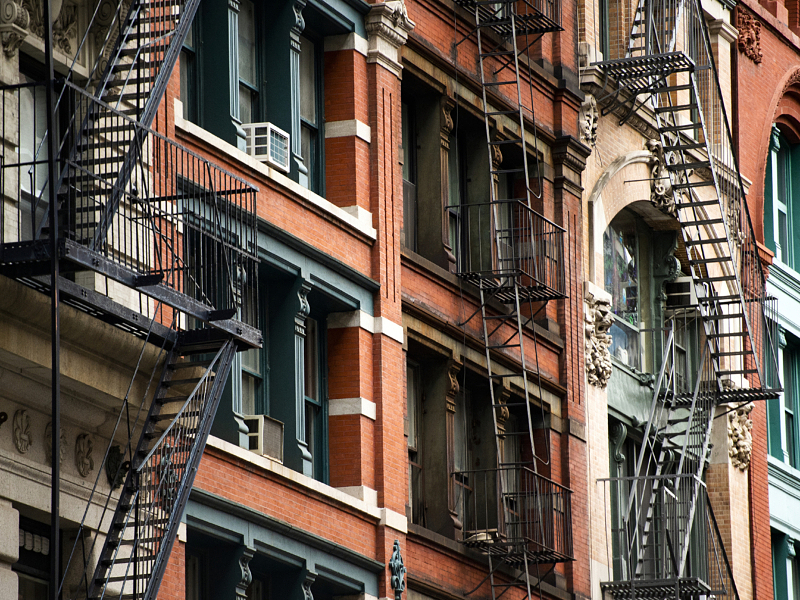 Close-up view of New York City style apartment buildings with emergency stairs along Mott Street in Chinatown neighborhood of Manhattan, New York, United States..